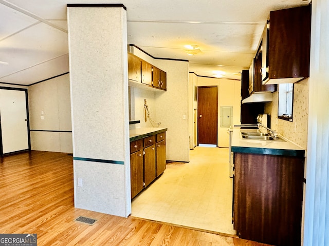 kitchen with a sink, light wood-type flooring, and light countertops