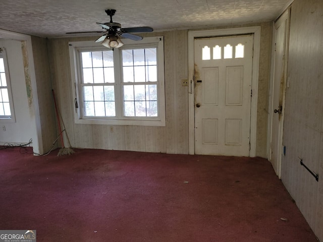 carpeted foyer with a ceiling fan