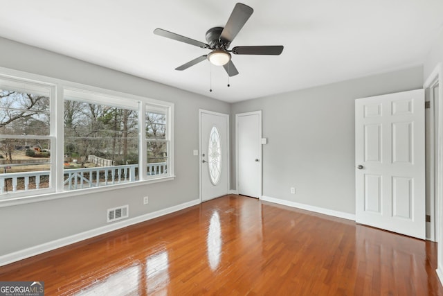 entrance foyer featuring visible vents, a ceiling fan, baseboards, and wood finished floors