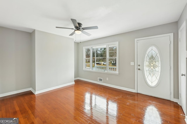 entrance foyer featuring visible vents, a ceiling fan, baseboards, and wood finished floors