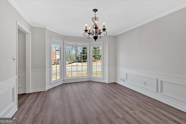 unfurnished dining area featuring dark wood-type flooring, ornamental molding, visible vents, and a chandelier