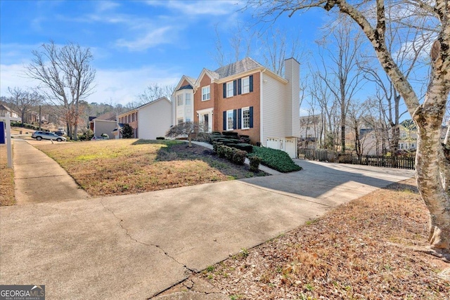 view of front of house with fence, driveway, a chimney, a garage, and brick siding