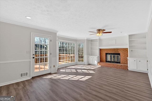 unfurnished living room featuring a fireplace, a textured ceiling, crown molding, and wood finished floors