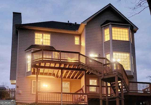 back of property featuring a wooden deck, stairway, and a chimney