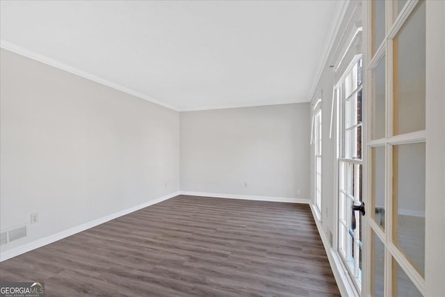 unfurnished room featuring visible vents, baseboards, dark wood finished floors, ornamental molding, and french doors