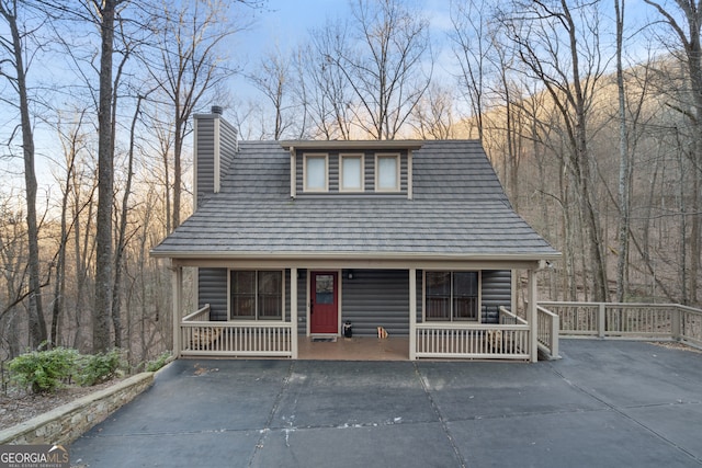 rustic home featuring a porch and a chimney