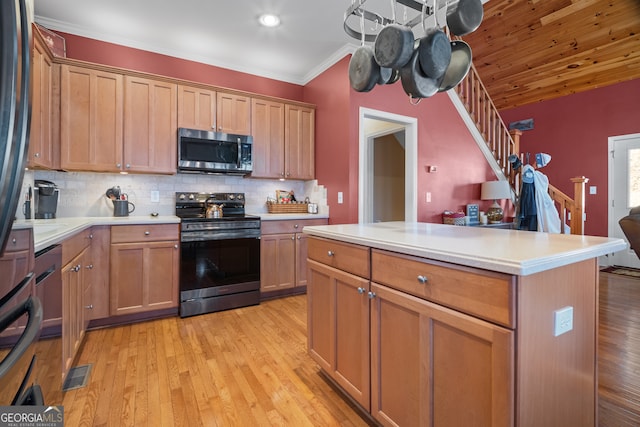 kitchen with visible vents, backsplash, light countertops, appliances with stainless steel finishes, and light wood-style floors