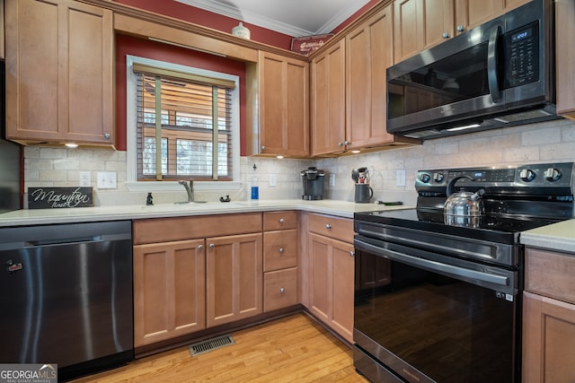 kitchen with a sink, backsplash, black / electric stove, light countertops, and dishwasher