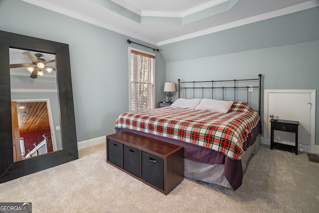 bedroom featuring baseboards, light colored carpet, a raised ceiling, and crown molding