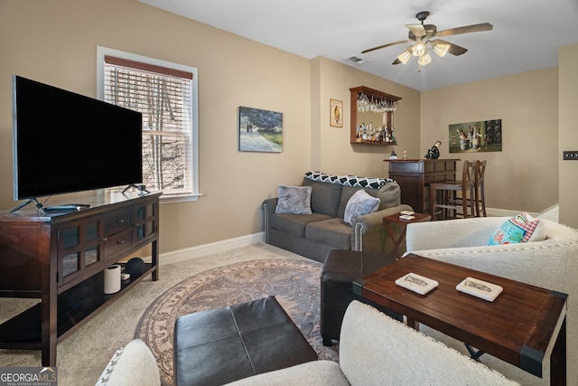 carpeted living room with visible vents, baseboards, a bar, and ceiling fan