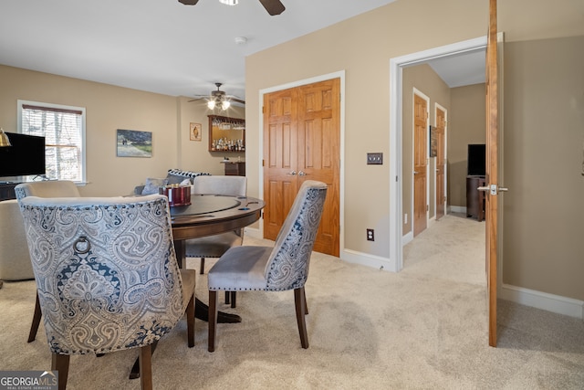 dining room with light colored carpet, baseboards, and ceiling fan