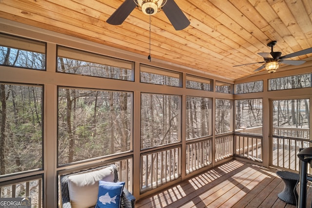 unfurnished sunroom with ceiling fan, wooden ceiling, a wealth of natural light, and vaulted ceiling