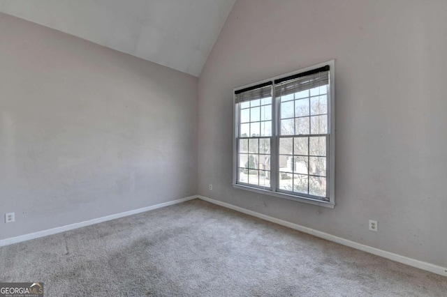 empty room with baseboards, carpet, and high vaulted ceiling