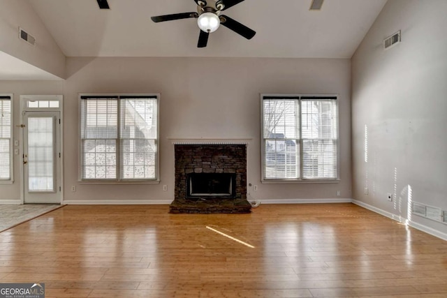 unfurnished living room with a fireplace, wood finished floors, visible vents, and ceiling fan