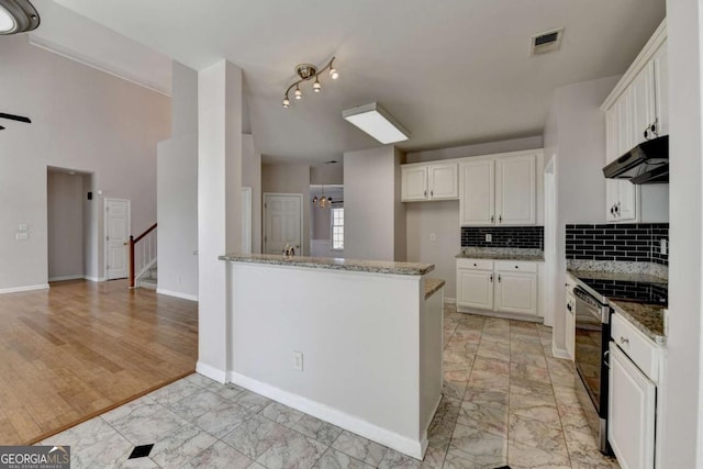 kitchen featuring visible vents, stone counters, under cabinet range hood, black electric range oven, and marble finish floor