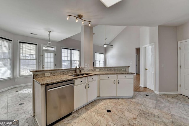 kitchen featuring dishwasher, lofted ceiling, marble finish floor, white cabinetry, and a sink