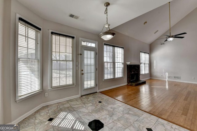 unfurnished living room with a fireplace, visible vents, and baseboards
