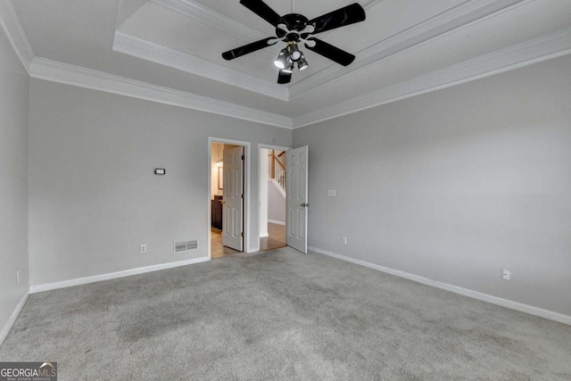 unfurnished bedroom with visible vents, crown molding, a raised ceiling, and baseboards