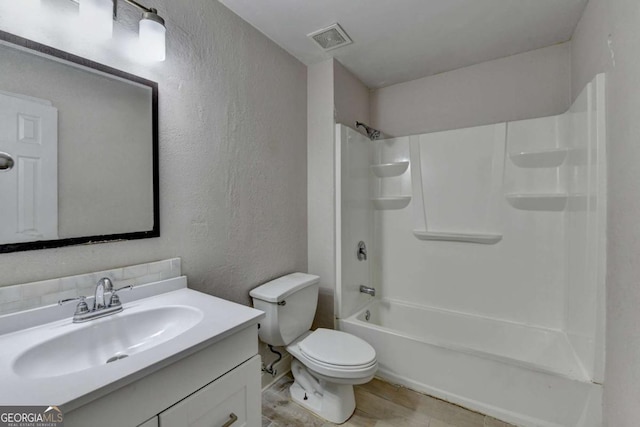 full bath with vanity, visible vents, shower / washtub combination, toilet, and a textured wall