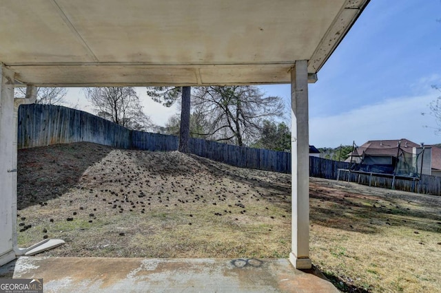 view of yard with a trampoline and a fenced backyard