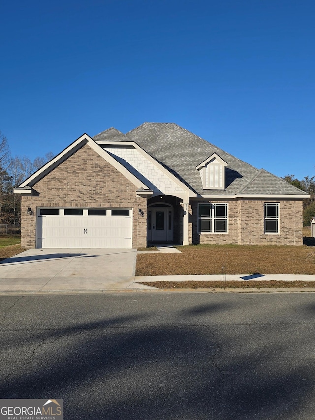 view of front of property featuring a garage, brick siding, roof with shingles, and driveway