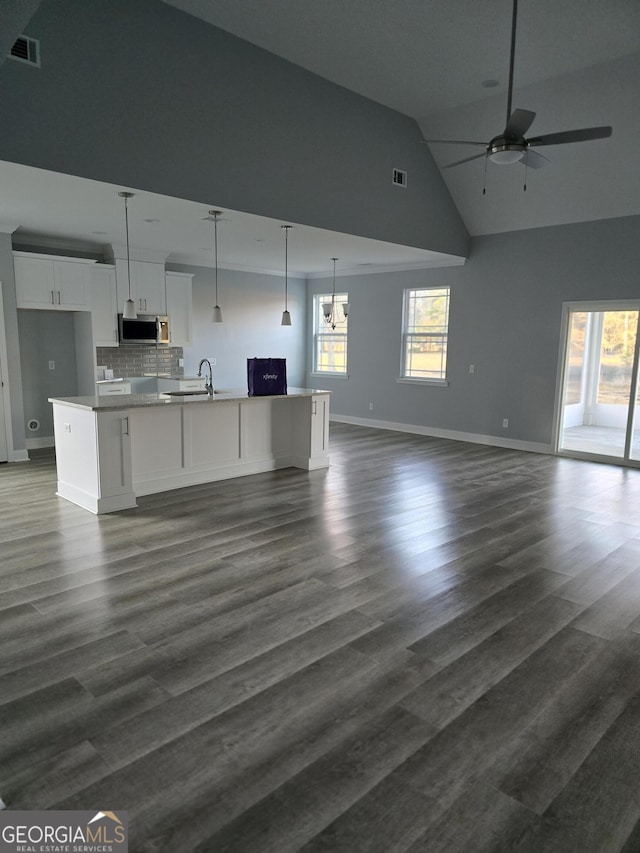 kitchen with white cabinetry, stainless steel microwave, visible vents, and open floor plan