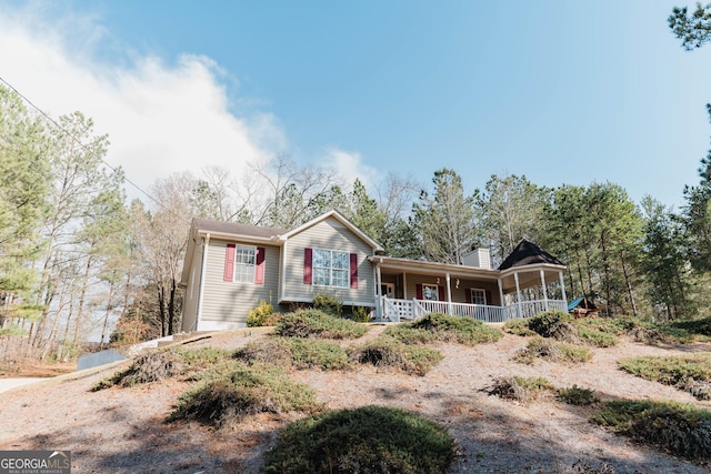 single story home with a porch and a chimney