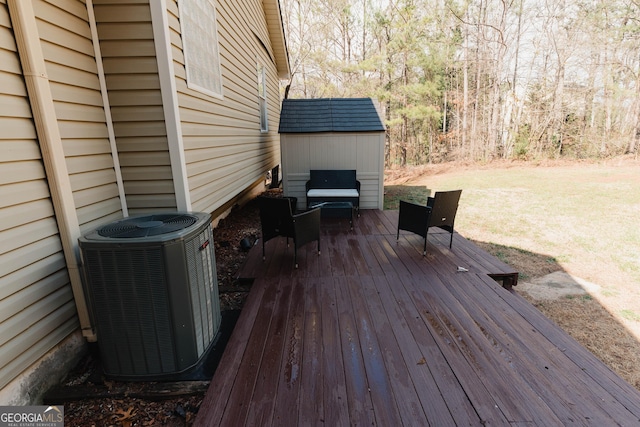 wooden terrace with an outbuilding, central air condition unit, and a shed