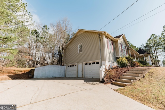 view of home's exterior featuring an attached garage and driveway