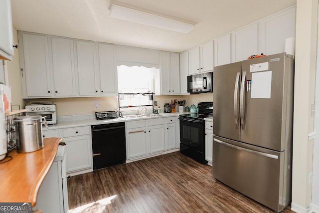 kitchen featuring dark wood-type flooring, black appliances, a textured ceiling, white cabinets, and light countertops