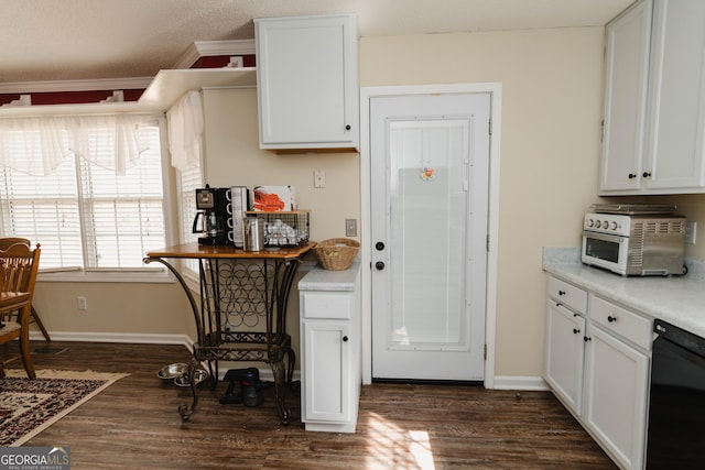 kitchen with dark wood-type flooring, white cabinetry, light countertops, baseboards, and dishwasher