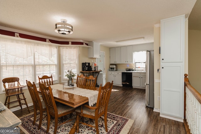 dining room with a wealth of natural light, baseboards, dark wood-type flooring, and a textured ceiling