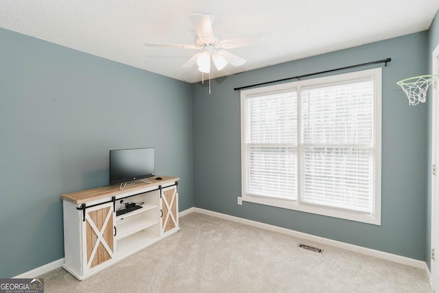 interior space with a ceiling fan, carpet, baseboards, and visible vents