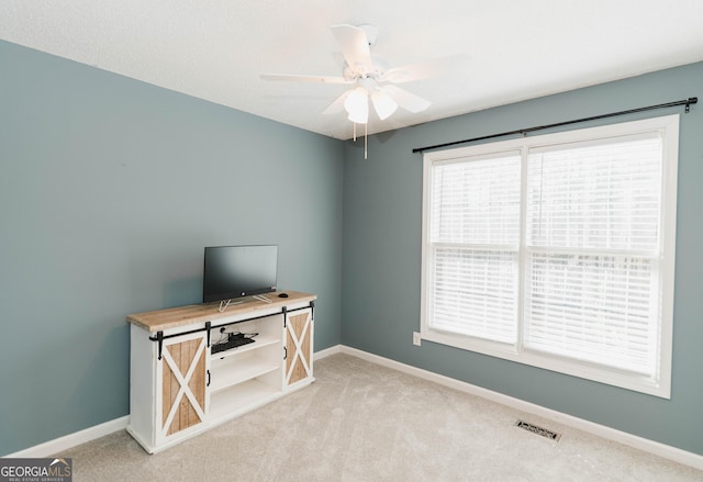 interior space with visible vents, baseboards, and a ceiling fan