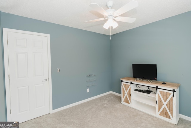 interior space with baseboards, carpet floors, and a ceiling fan