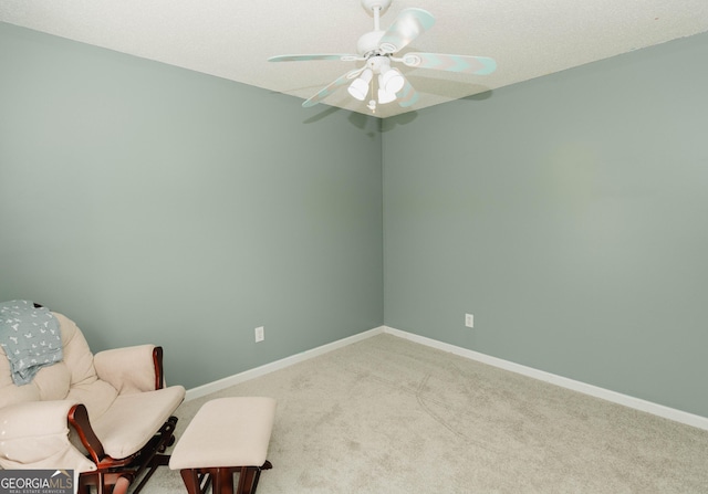 sitting room featuring baseboards, carpet floors, and a ceiling fan