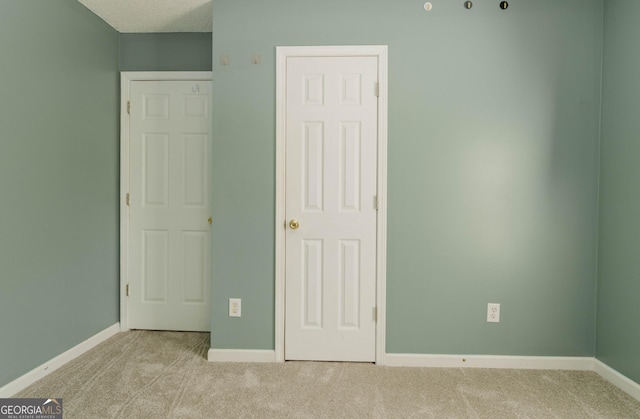 unfurnished bedroom featuring baseboards, carpet floors, and a textured ceiling