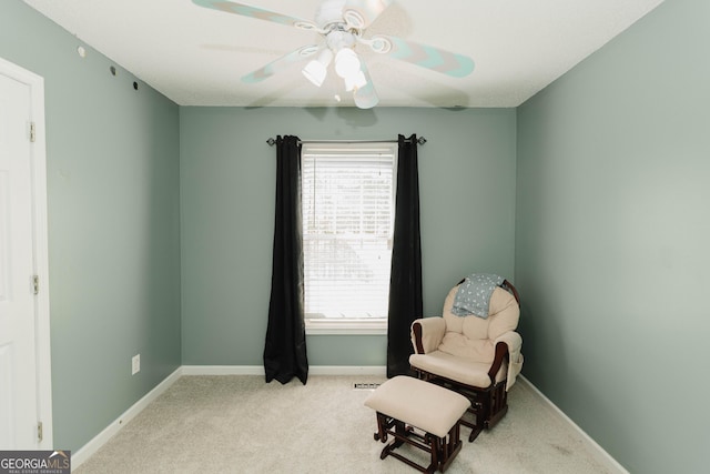 sitting room featuring baseboards, carpet, and a ceiling fan