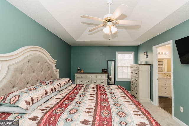 carpeted bedroom with a ceiling fan, a raised ceiling, and baseboards