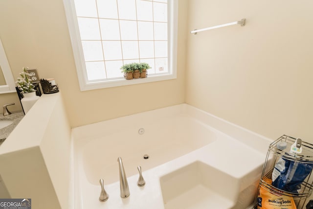 full bath featuring a tub with jets and a sink