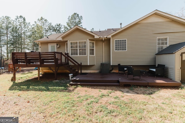 back of property with a storage shed, an outbuilding, a lawn, and a wooden deck