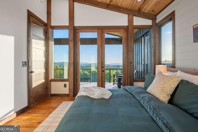 bedroom with light wood-style flooring, access to outside, a mountain view, wood ceiling, and vaulted ceiling