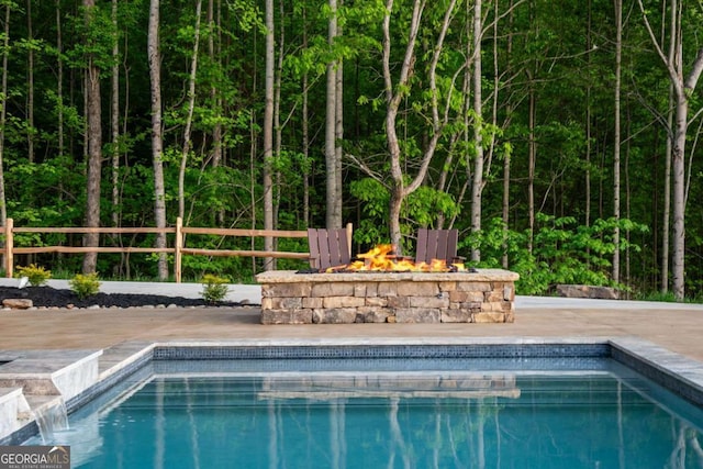 outdoor pool with a fire pit and fence