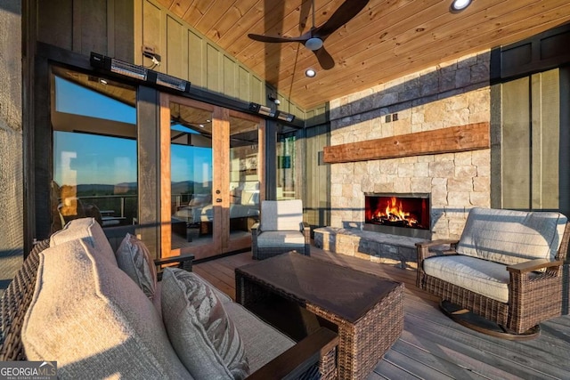 interior space featuring lofted ceiling, ceiling fan, an outdoor stone fireplace, hardwood / wood-style flooring, and wood ceiling