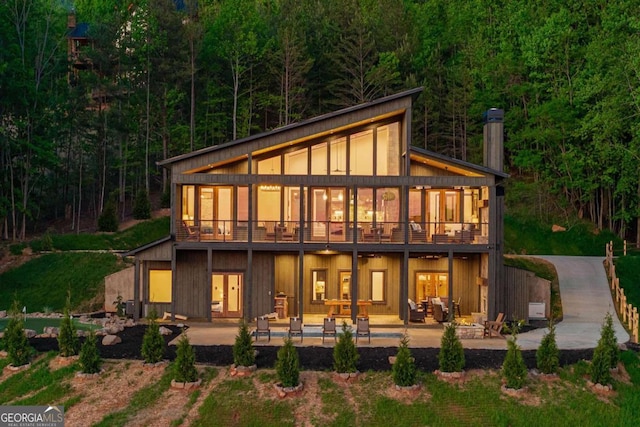 back of property with a chimney and a patio