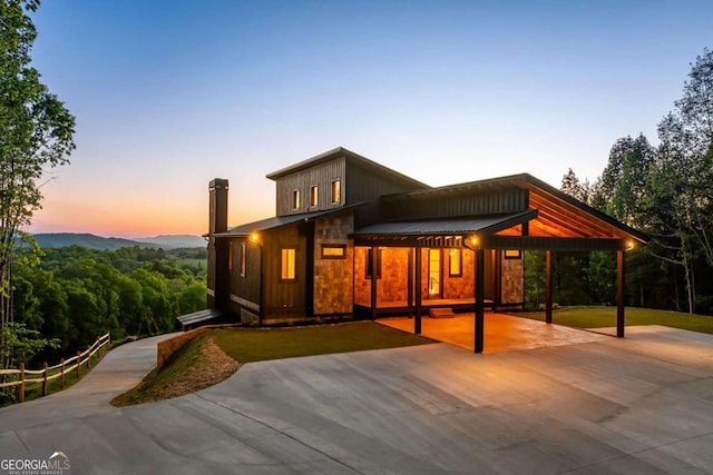 back of property featuring a carport and a chimney