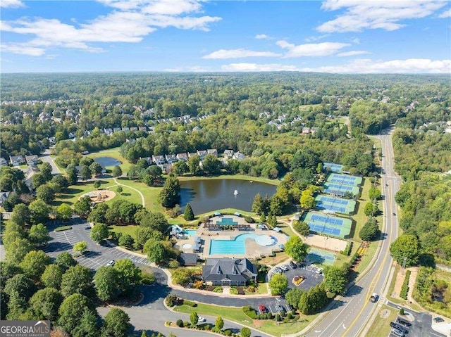 aerial view featuring a forest view and a water view