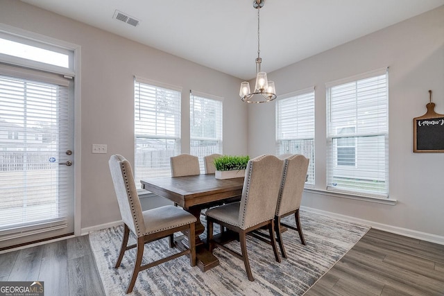 dining room with visible vents, a healthy amount of sunlight, and wood finished floors