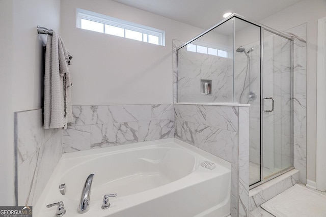 full bathroom featuring a bath and a shower stall