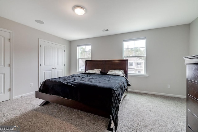 bedroom featuring carpet flooring, baseboards, visible vents, and a closet